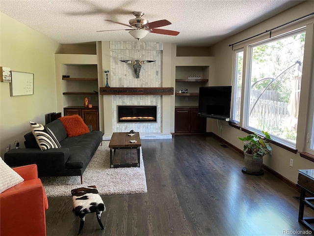 living room featuring a wealth of natural light, a textured ceiling, and built in features