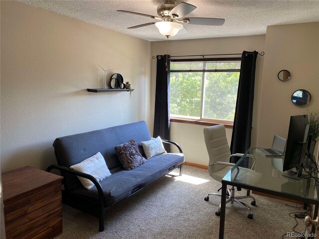 carpeted office with baseboards, a textured ceiling, and a ceiling fan