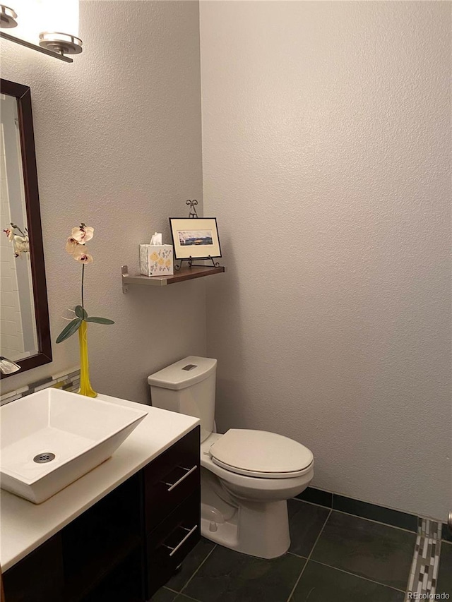 half bathroom with tile patterned floors, vanity, and toilet