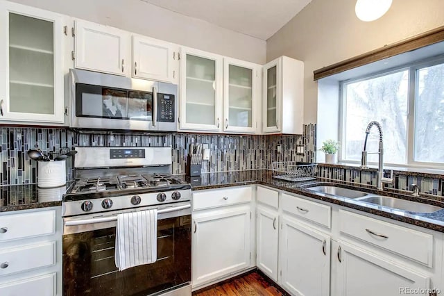 6365 Xavier Ct, Arvada, CO 80003 - kitchen featuring appliances with stainless steel finishes, a sink, white cabinetry, and dark stone counters