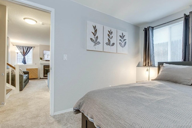 6365 Xavier Ct, Arvada, CO 80003 - bedroom featuring light carpet, a glass covered fireplace, and baseboards