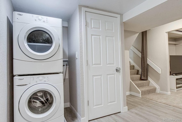 6365 Xavier Ct, Arvada, CO 80003 - washroom featuring stacked washer and clothes dryer, wood finished floors, and baseboards