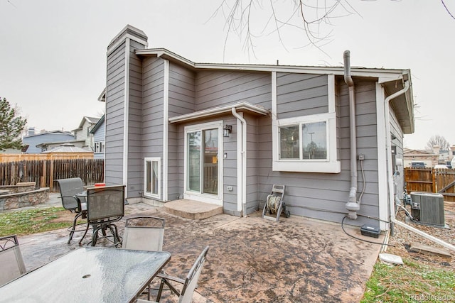 6365 Xavier Ct, Arvada, CO 80003 - rear view of property with a patio, outdoor dining area, cooling unit, and a chimney