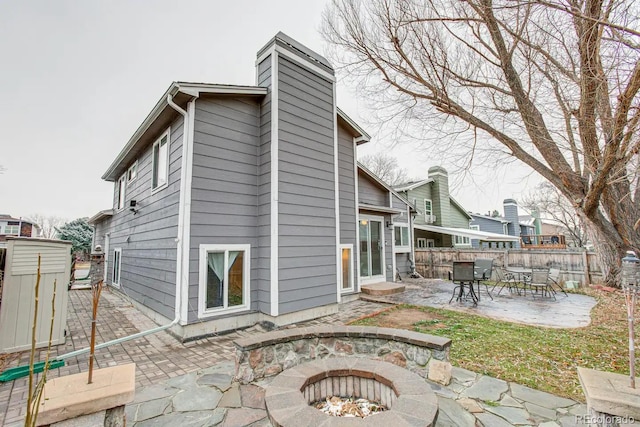 6365 Xavier Ct, Arvada, CO 80003 - rear view of house featuring a patio area, a chimney, and an outdoor fire pit