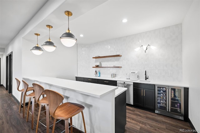 bar featuring dark wood-style floors, wet bar, beverage cooler, and stainless steel dishwasher