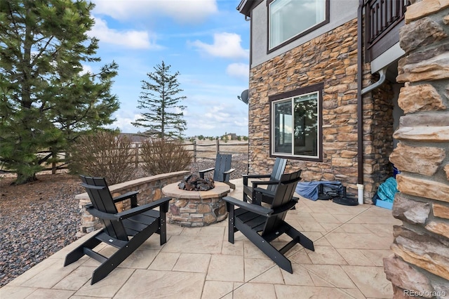 view of patio featuring fence and a fire pit