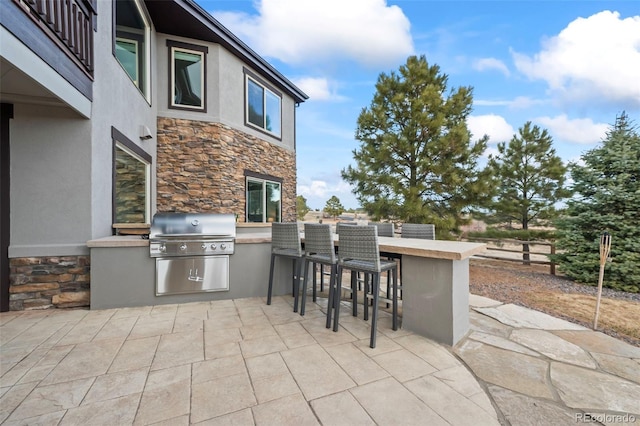 view of patio featuring outdoor wet bar, an outdoor kitchen, and area for grilling