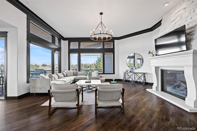 living room featuring a fireplace, crown molding, a notable chandelier, and wood finished floors