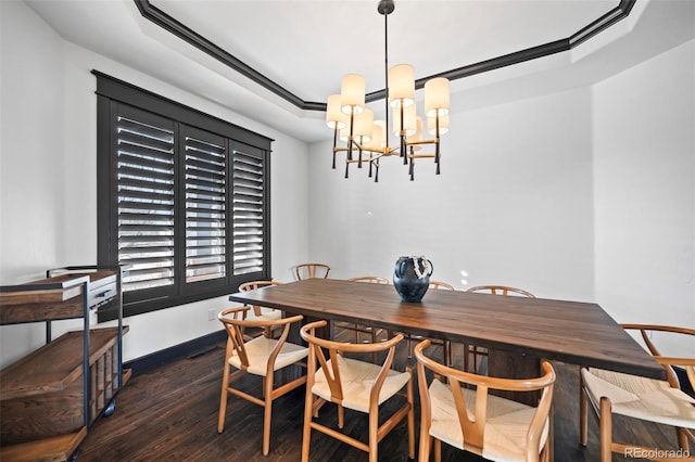 dining space with baseboards, wood finished floors, a raised ceiling, and a notable chandelier