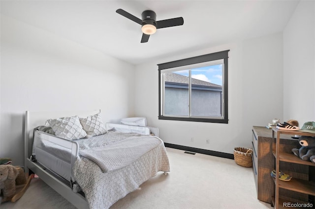 carpeted bedroom with visible vents, baseboards, and a ceiling fan