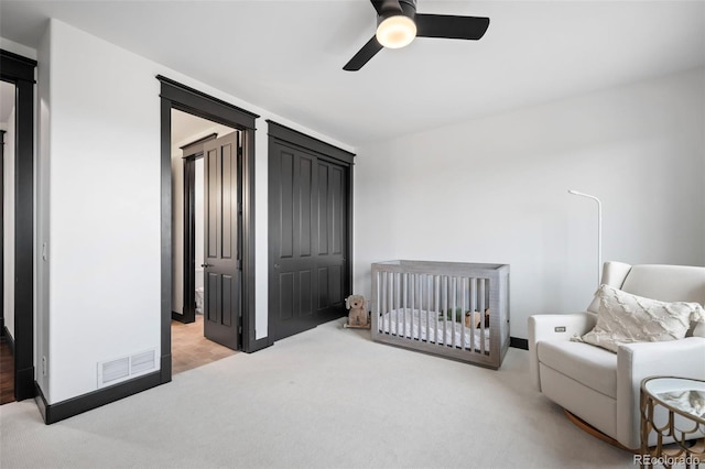 carpeted bedroom featuring ceiling fan, visible vents, and baseboards