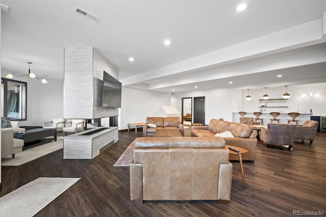 living room featuring recessed lighting, visible vents, and dark wood finished floors