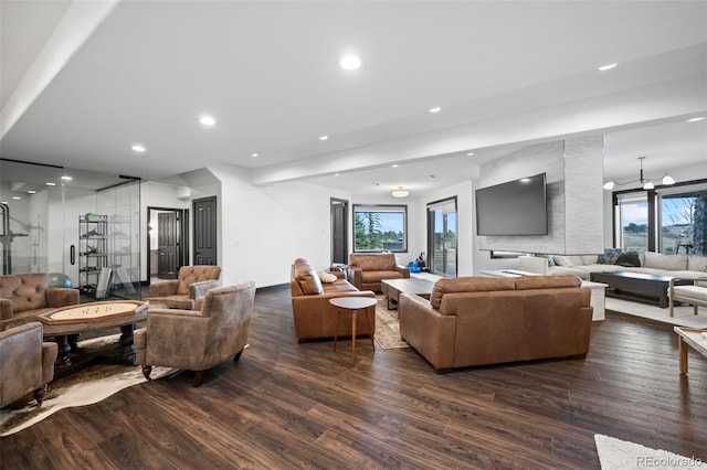 living area with dark wood-type flooring and recessed lighting