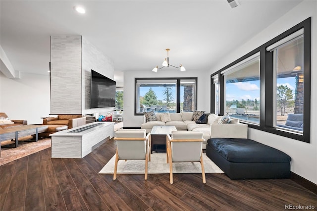 living area featuring an inviting chandelier, dark wood-type flooring, and recessed lighting