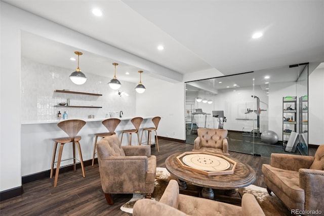 living room with recessed lighting, indoor wet bar, baseboards, and wood finished floors