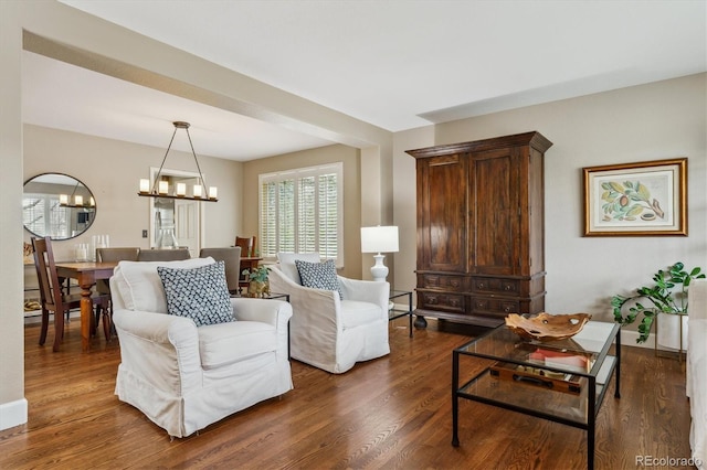 living room with a chandelier and dark wood-style floors