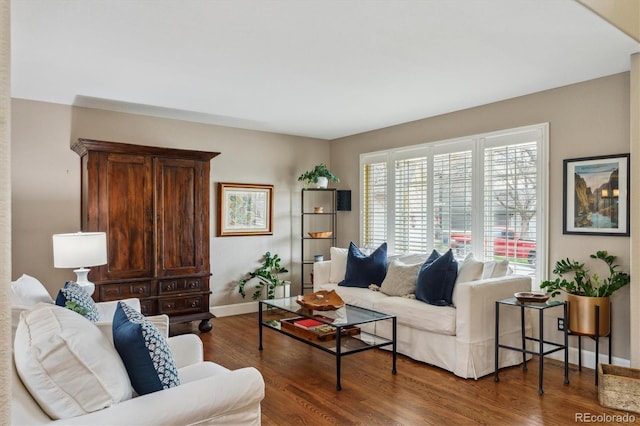 living area with baseboards and wood finished floors