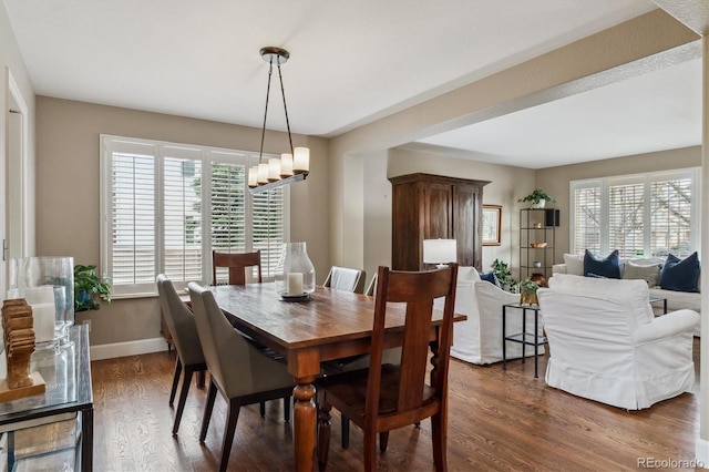 dining space with an inviting chandelier, a wealth of natural light, baseboards, and dark wood-style floors