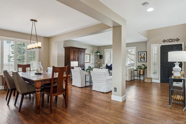 dining room featuring a chandelier, baseboards, and dark wood-style floors
