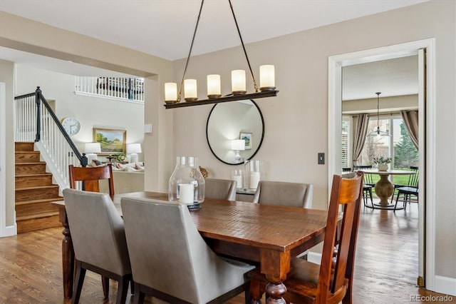 dining area with baseboards, stairs, and wood finished floors