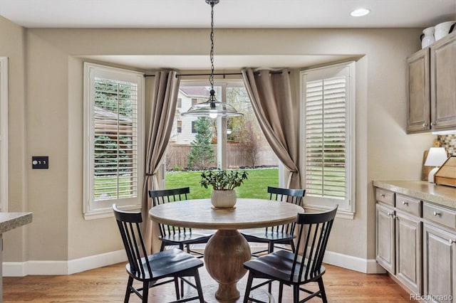 dining room featuring light wood finished floors, baseboards, and recessed lighting