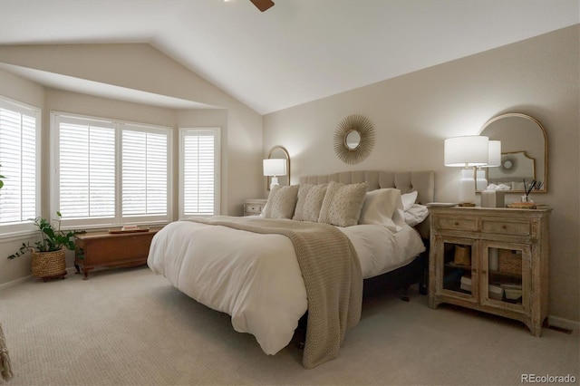 bedroom featuring light colored carpet, lofted ceiling, a ceiling fan, and multiple windows