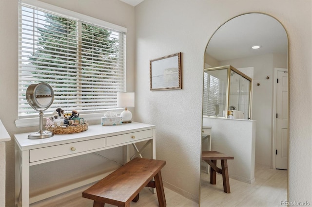 bathroom featuring a textured wall, baseboards, and a shower stall