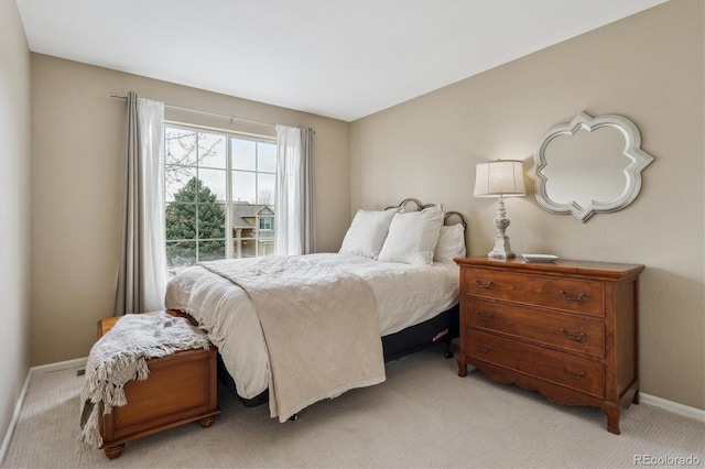 bedroom featuring baseboards and light carpet
