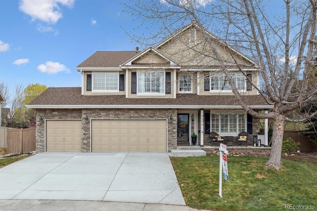 view of front of home with covered porch, fence, driveway, a front yard, and a shingled roof