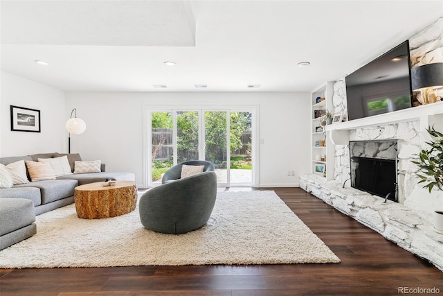 6488 S Heritage Pl E, Centennial, CO 80111 - living room featuring dark wood finished floors, a fireplace, recessed lighting, baseboards, and built in shelves