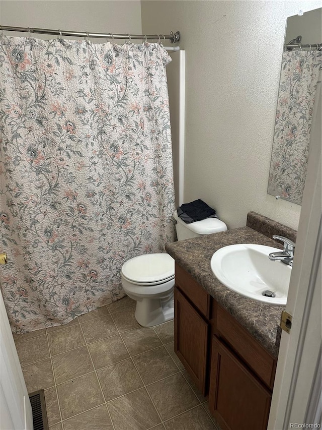 bathroom featuring vanity, tile patterned floors, and toilet