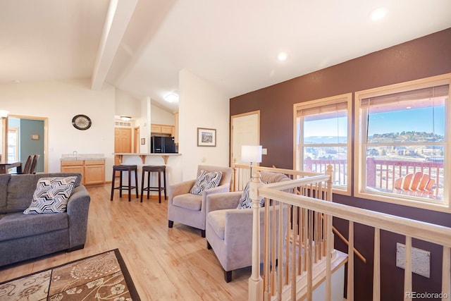 living room with lofted ceiling with beams and light wood-type flooring