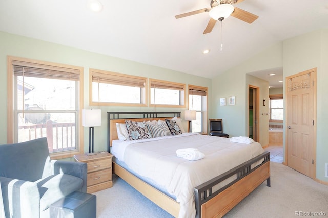 carpeted bedroom featuring connected bathroom, vaulted ceiling, and ceiling fan