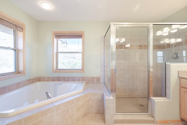 bathroom featuring vanity and independent shower and bath