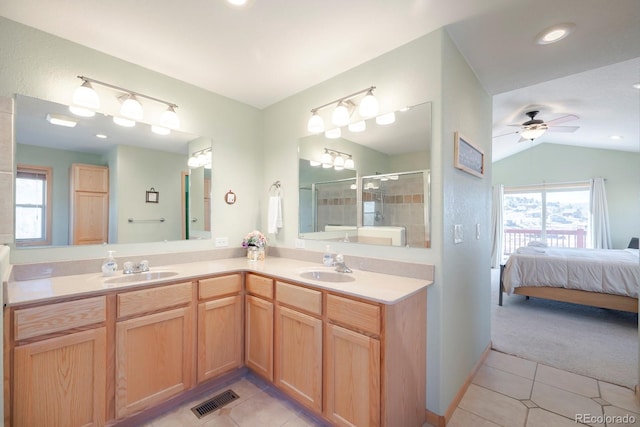 bathroom featuring ceiling fan, lofted ceiling, a shower with shower door, and tile patterned flooring