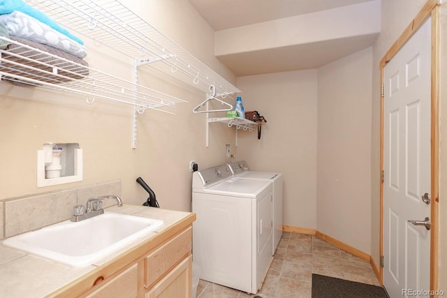 washroom with washer and dryer, light tile patterned flooring, and sink