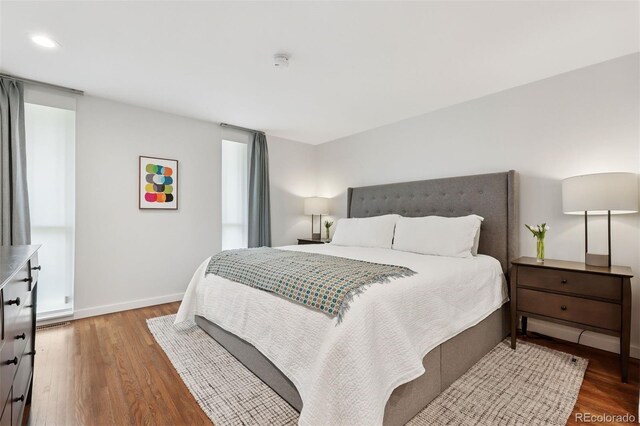 bedroom with baseboards, recessed lighting, and wood finished floors