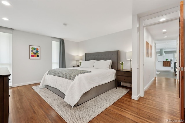 bedroom featuring baseboards, recessed lighting, and wood finished floors