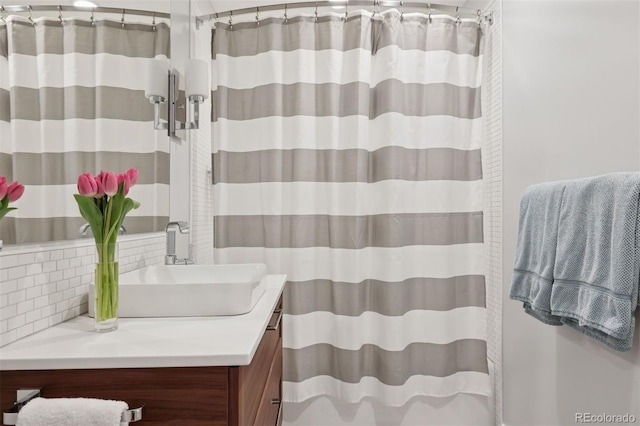 full bath with vanity, backsplash, and curtained shower