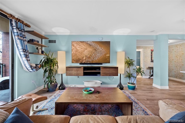 living area featuring ornamental molding, visible vents, baseboards, and wood finished floors