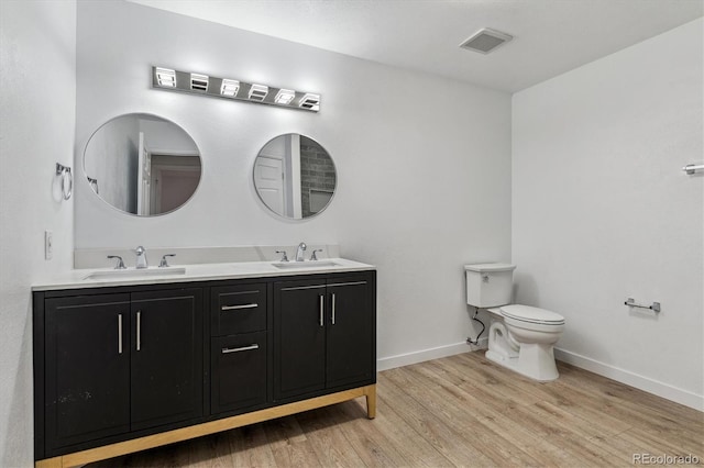 full bathroom with visible vents, toilet, wood finished floors, and a sink