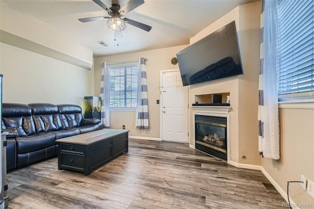 living room with ceiling fan and dark wood-type flooring