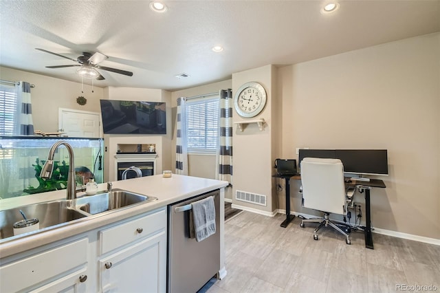 kitchen with a wealth of natural light, dishwasher, sink, and white cabinets