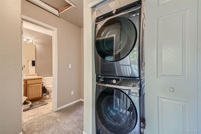 laundry room featuring light colored carpet and stacked washer / dryer