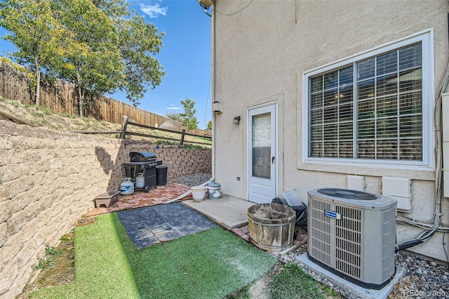 view of yard with central air condition unit and a patio