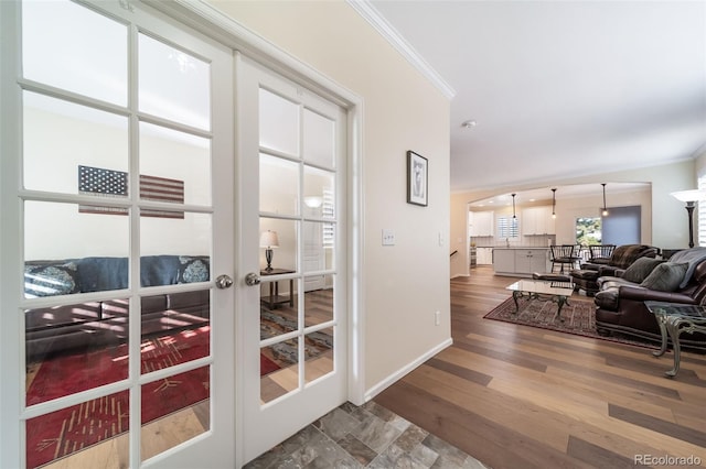 entryway with hardwood / wood-style floors, crown molding, and french doors