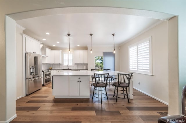 kitchen featuring white cabinetry, dark wood-type flooring, decorative light fixtures, high quality appliances, and a kitchen island