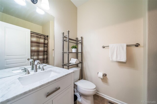 bathroom featuring tile patterned floors, vanity, and toilet