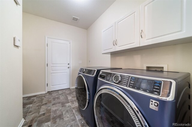 laundry area with washer and dryer and cabinets