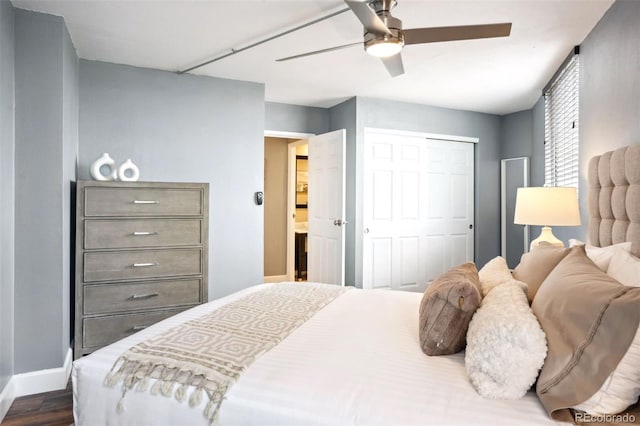 bedroom with ceiling fan, dark hardwood / wood-style flooring, and a closet